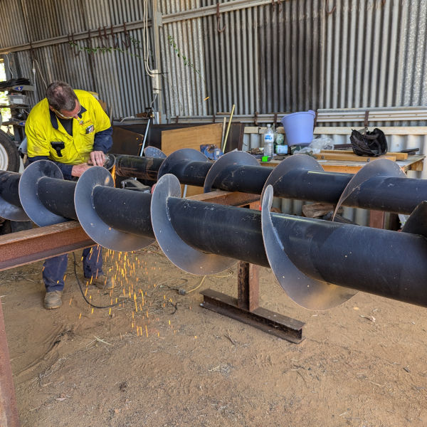 boilermaker welder fitting flighting on auger
